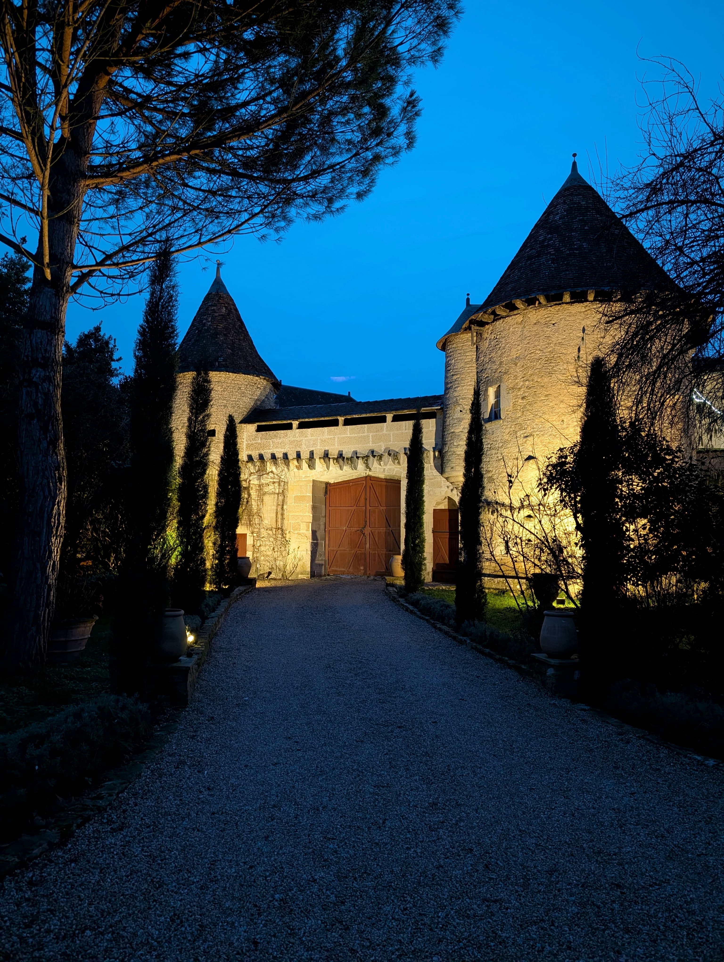 Château Lesvescault — the front gate and 15th-century towers at night