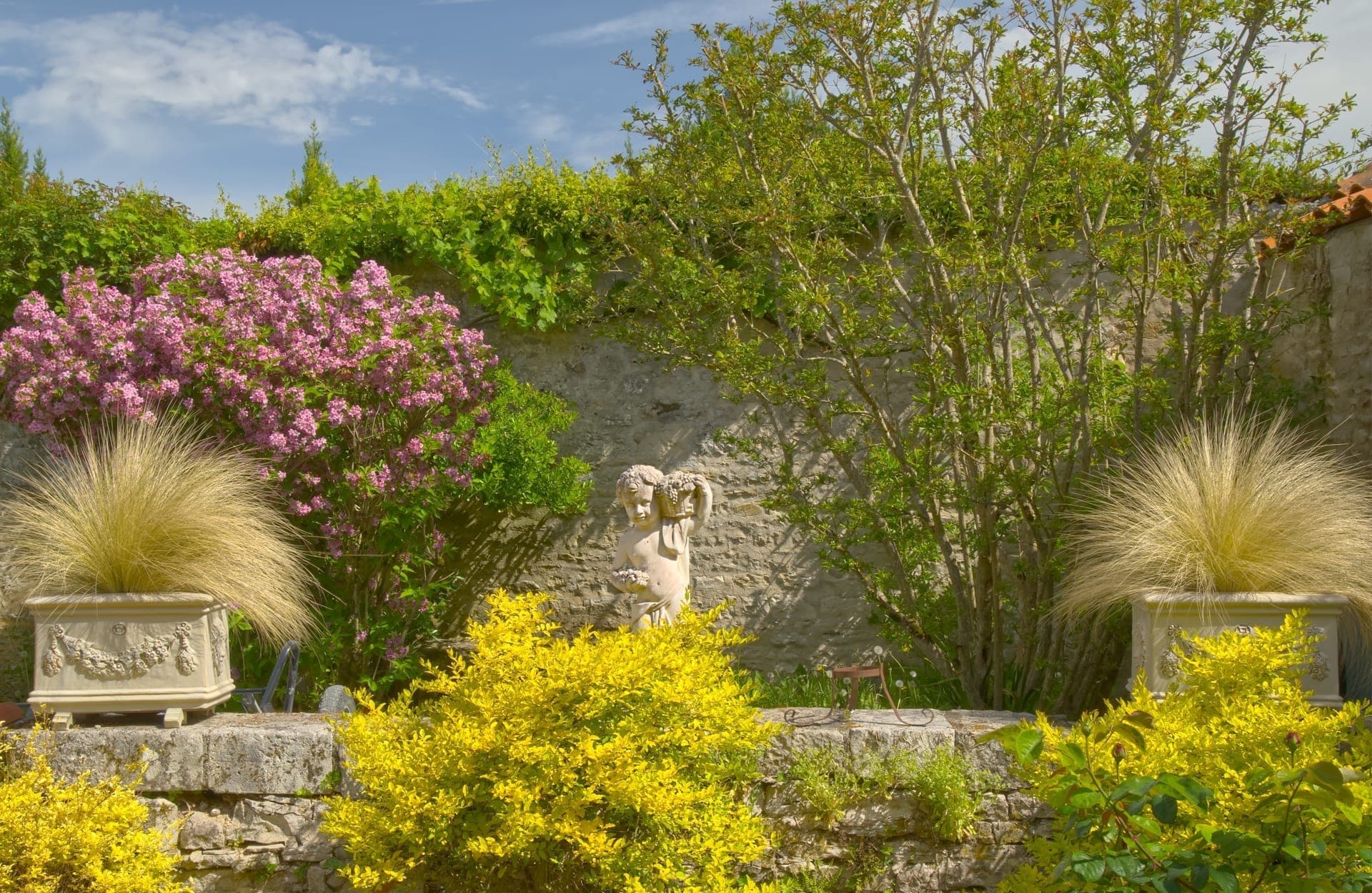 Château Lesvescault — stone cherub statue among the rose parterres