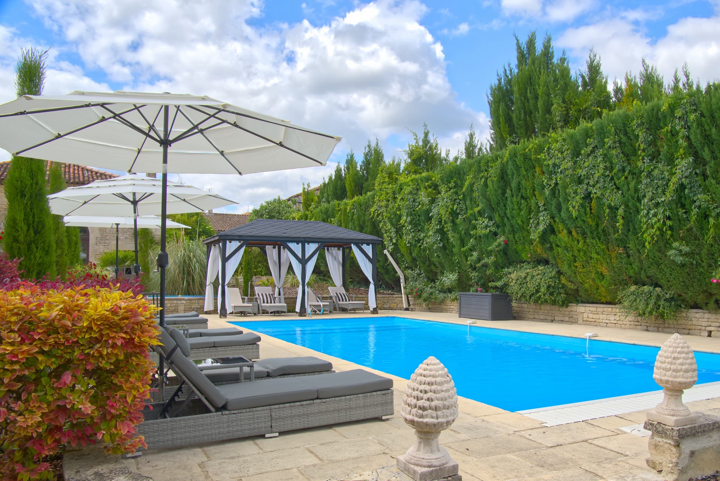 Château Lesvescault — heated saltwater pool with sunloungers and poolside cabana