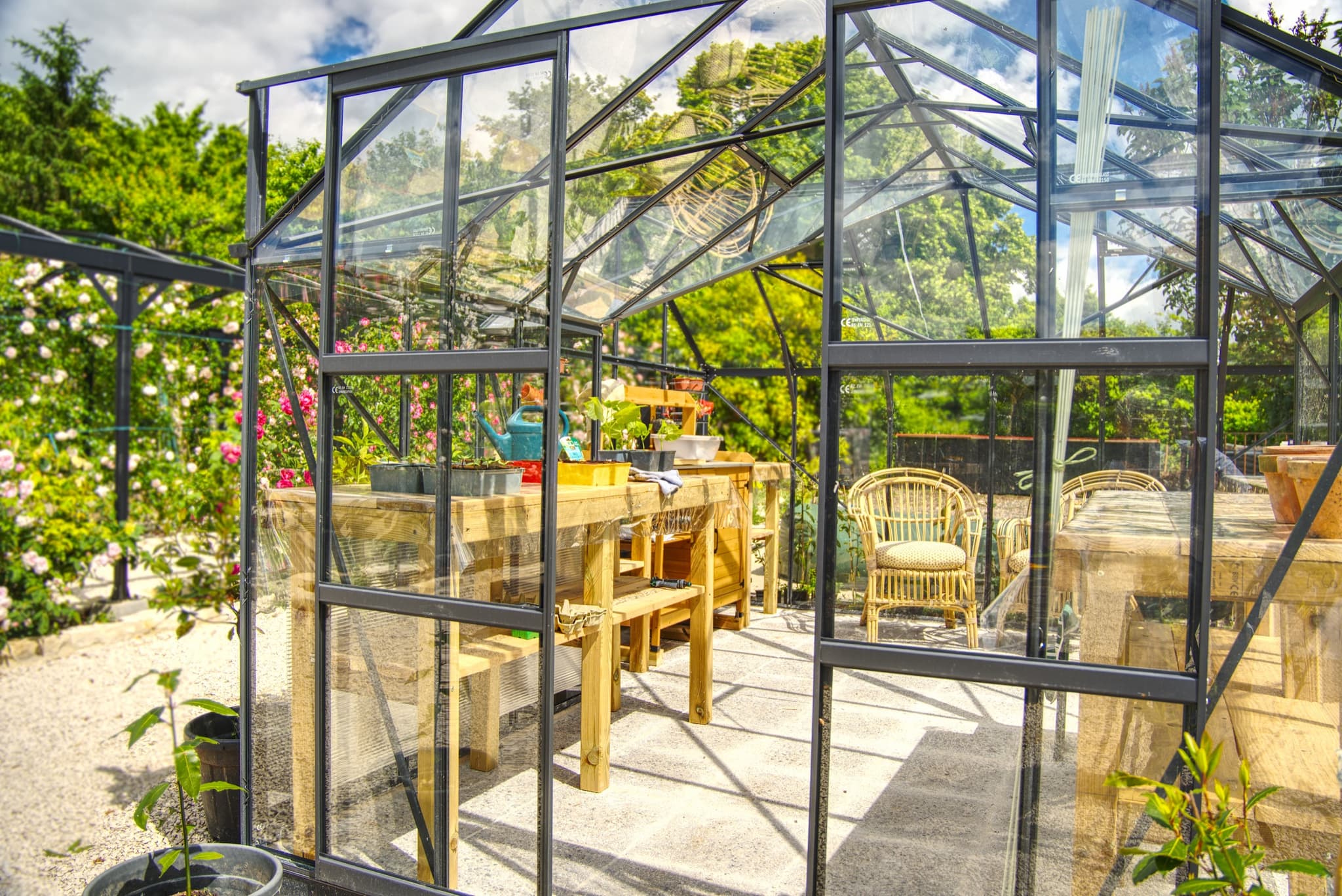 Château Lesvescault — inside the potager greenhouse with potting tables and rattan chairs