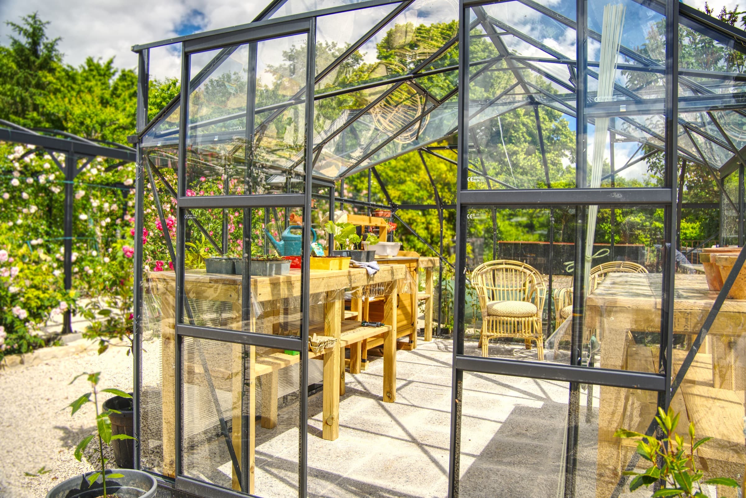 Château Lesvescault — inside the potager greenhouse with potting tables and rattan chairs