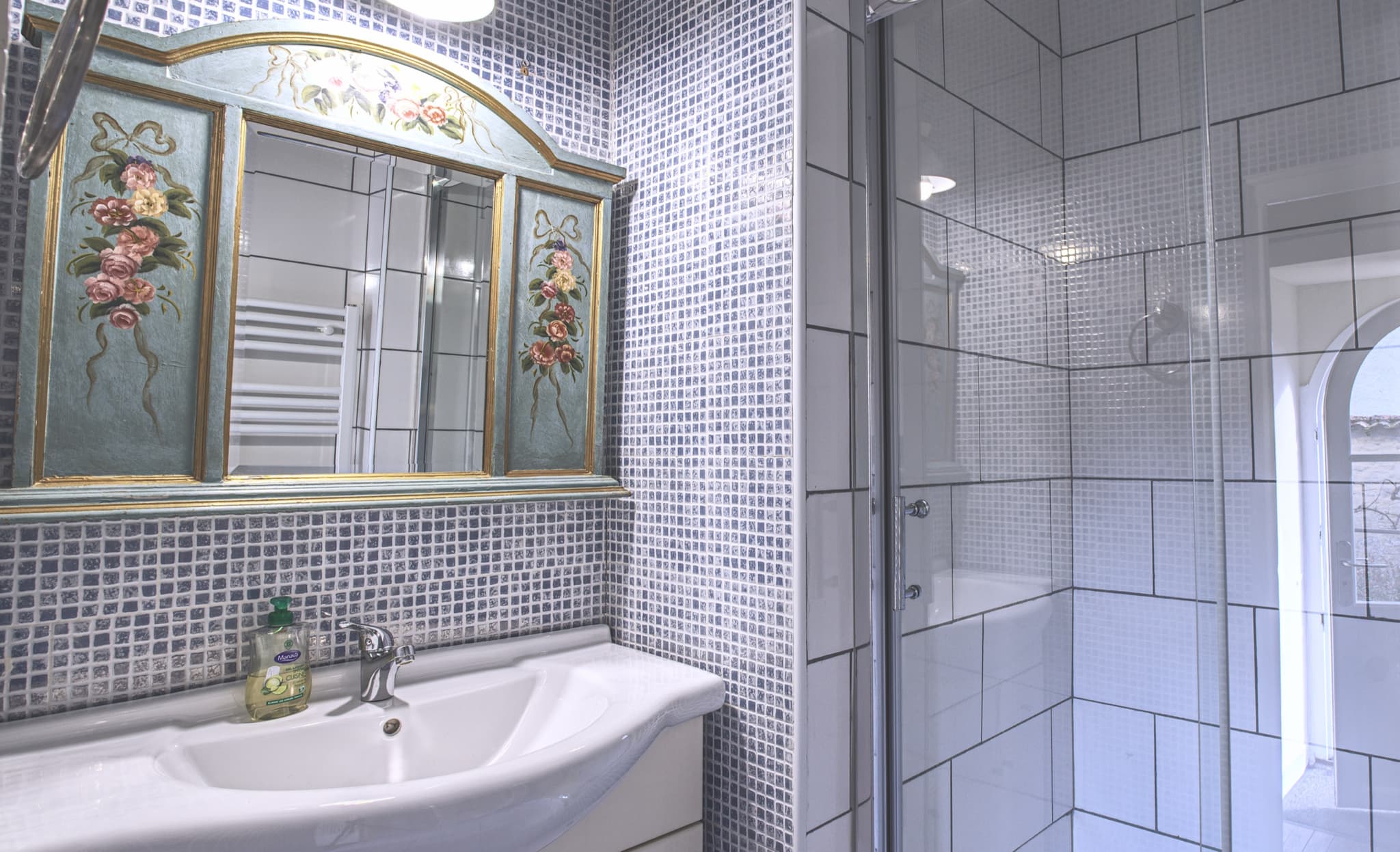 Maison Juliette — blue tiled bathroom with hand-painted mirror