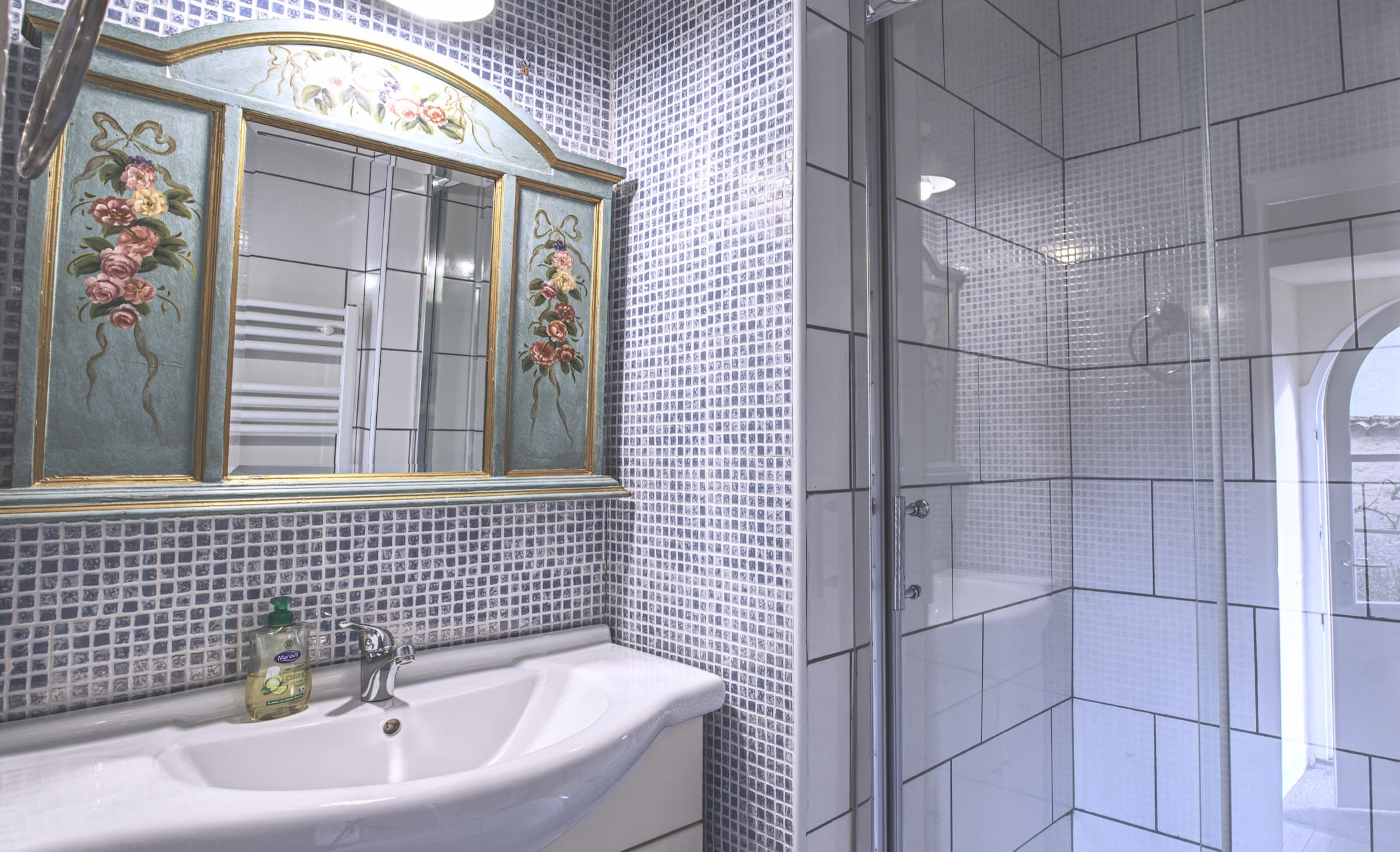 Maison Juliette — blue tiled bathroom with hand-painted mirror