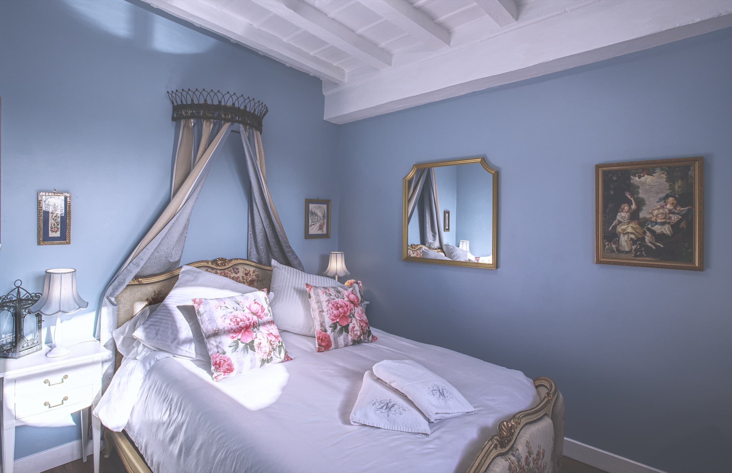 Maison Juliette — full view of the blue bedroom with canopy, antique furnishings and finely pressed cotton linen