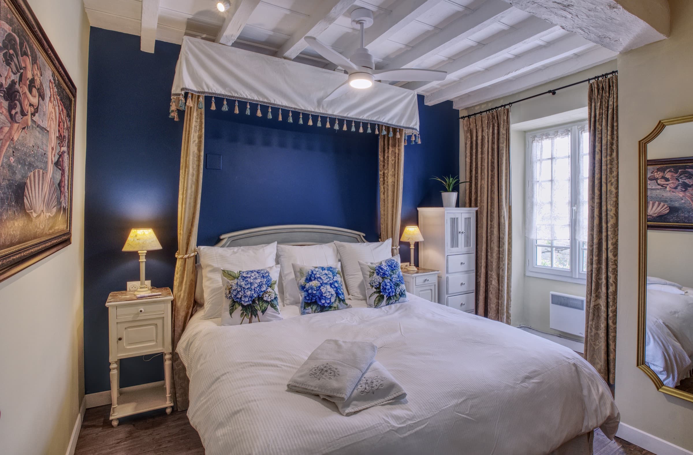 Maison Olivier — full view of the navy blue bedroom with four-poster canopy and hydrangea cushions, Château Lesvescault