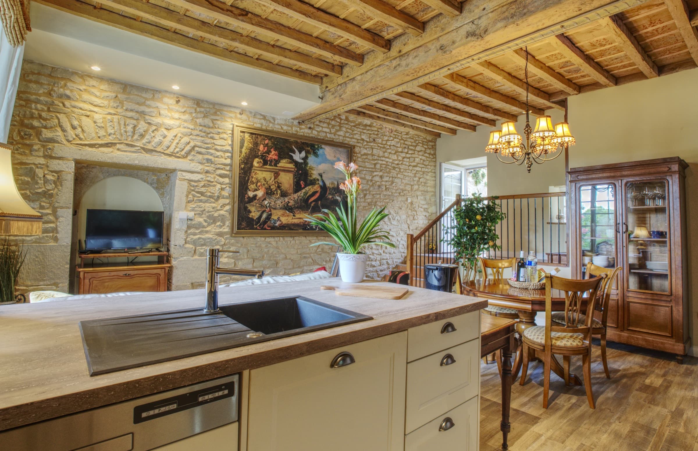 Maison Olivier — open-plan living room with large antique painting and beamed ceiling, Château Lesvescault